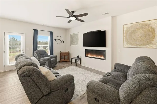 a living room with furniture a ceiling fan and a window