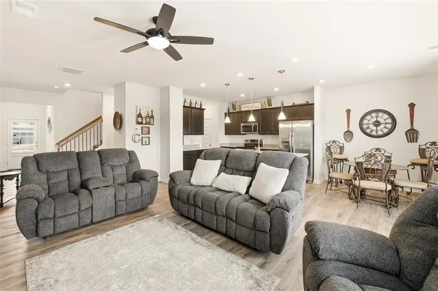 a living room with furniture kitchen view and a chandelier
