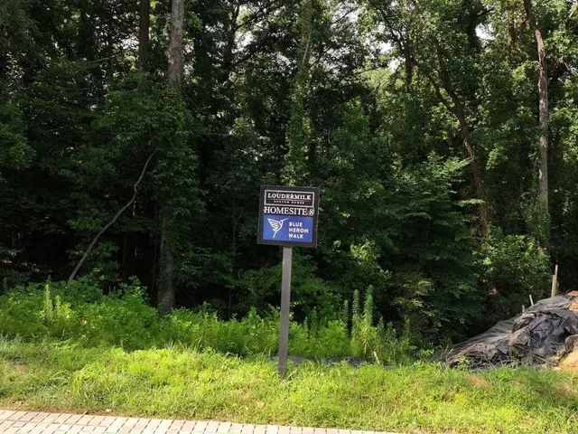 a sign that is sitting in front of a tree