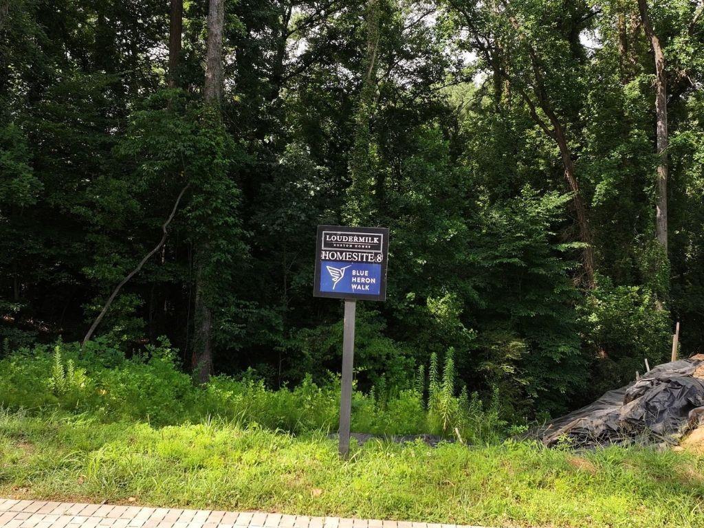 a sign that is sitting in front of a tree