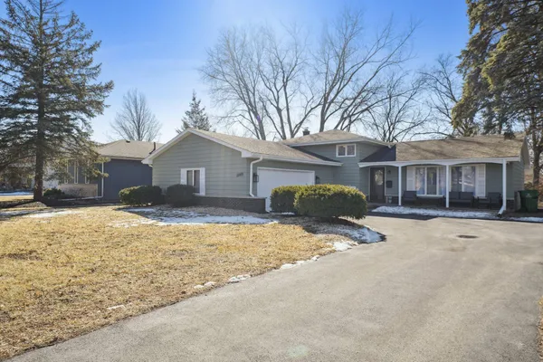a front view of a house with a yard covered in snow