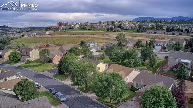 an aerial view of a city with lots of residential buildings ocean and mountain view in back
