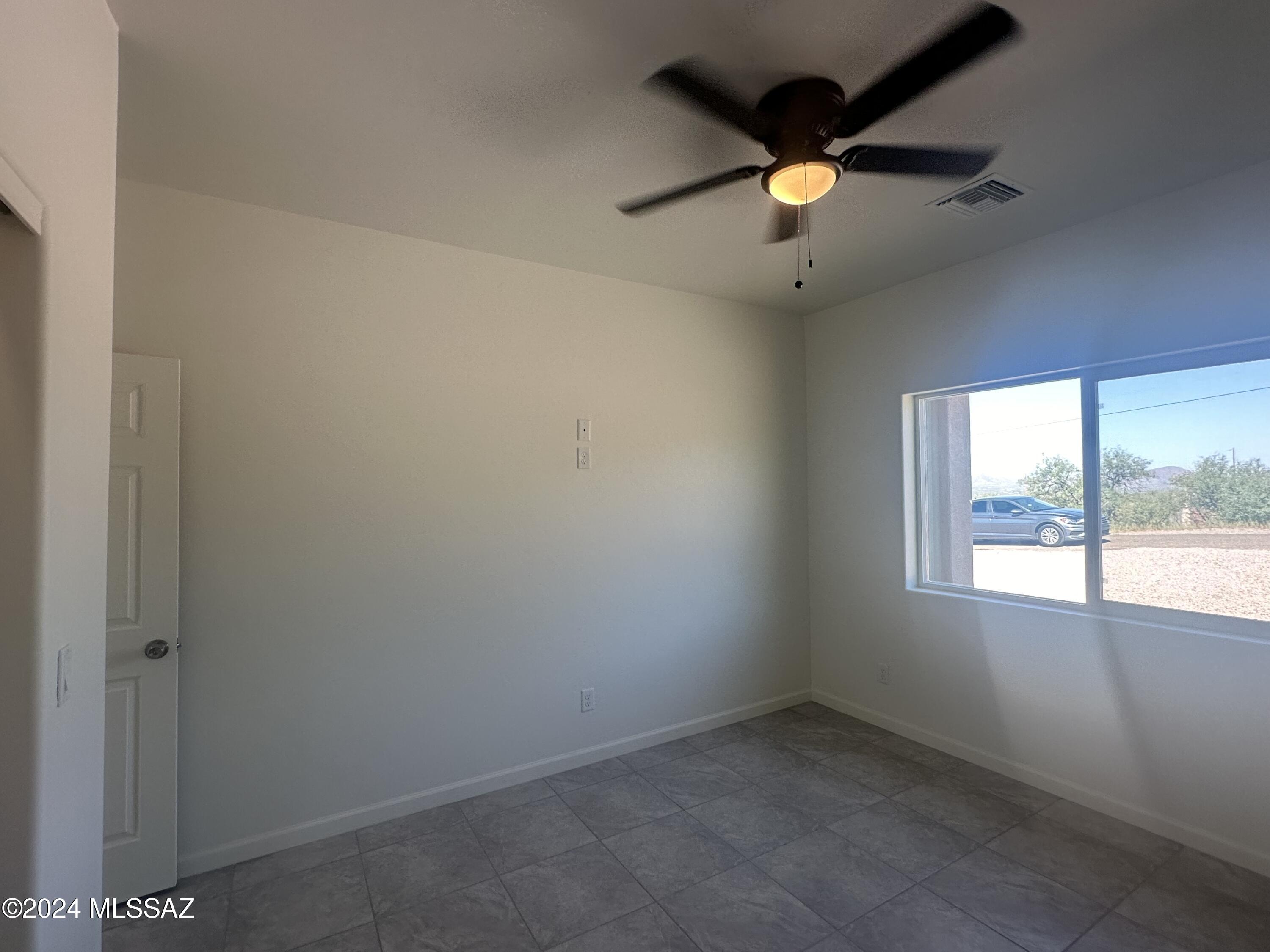 169 Camino Mar Rio Rico, AZ 85648 - Photo 18 of 40 an empty room with windows and a ceiling fan