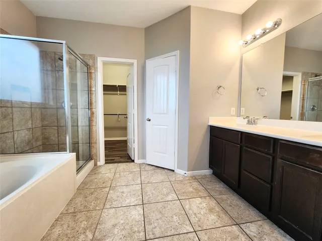 a spacious bathroom with a mirror a shower and a bathtub