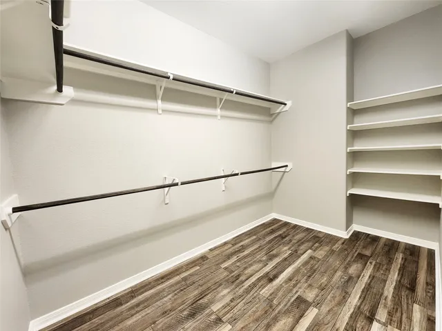 a view of walk in closet with empty racks