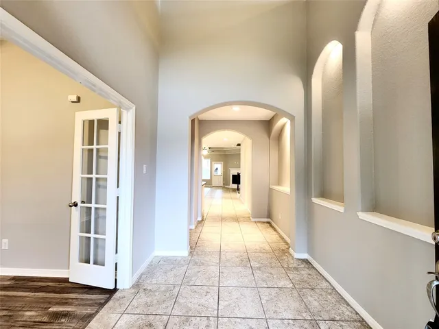 a view of a hallway with wooden floor and a living room
