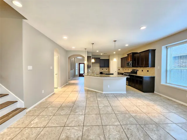 a large kitchen with a large counter top stainless steel appliances and cabinets