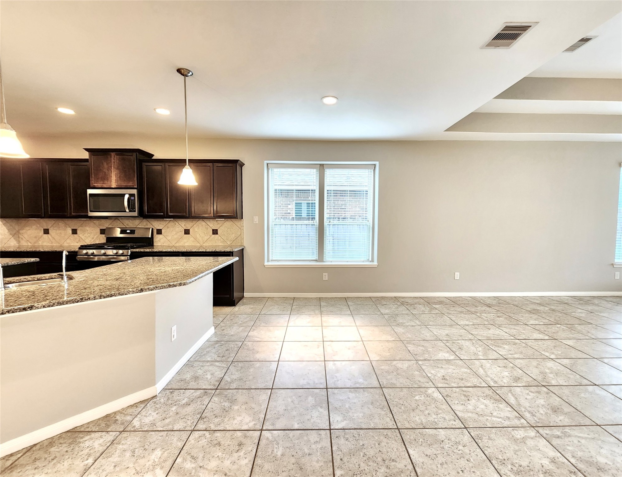 4407 Greenleaf Drive Spring, TX 77389 - Photo 10 of 29 a large kitchen with kitchen island granite countertop a large counter top a sink a stove a dining table and chairs