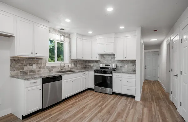 a bathroom with a granite countertop sink toilet a mirror and bathtub