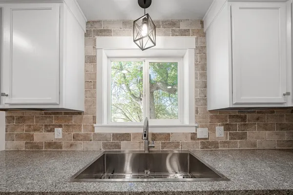 a view of staircase with lots of frames on wall and windows