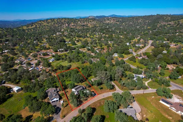 an aerial view of residential house with outdoor space and trees all around