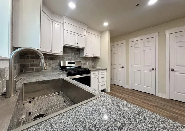 a front view of a house with a yard and potted plants