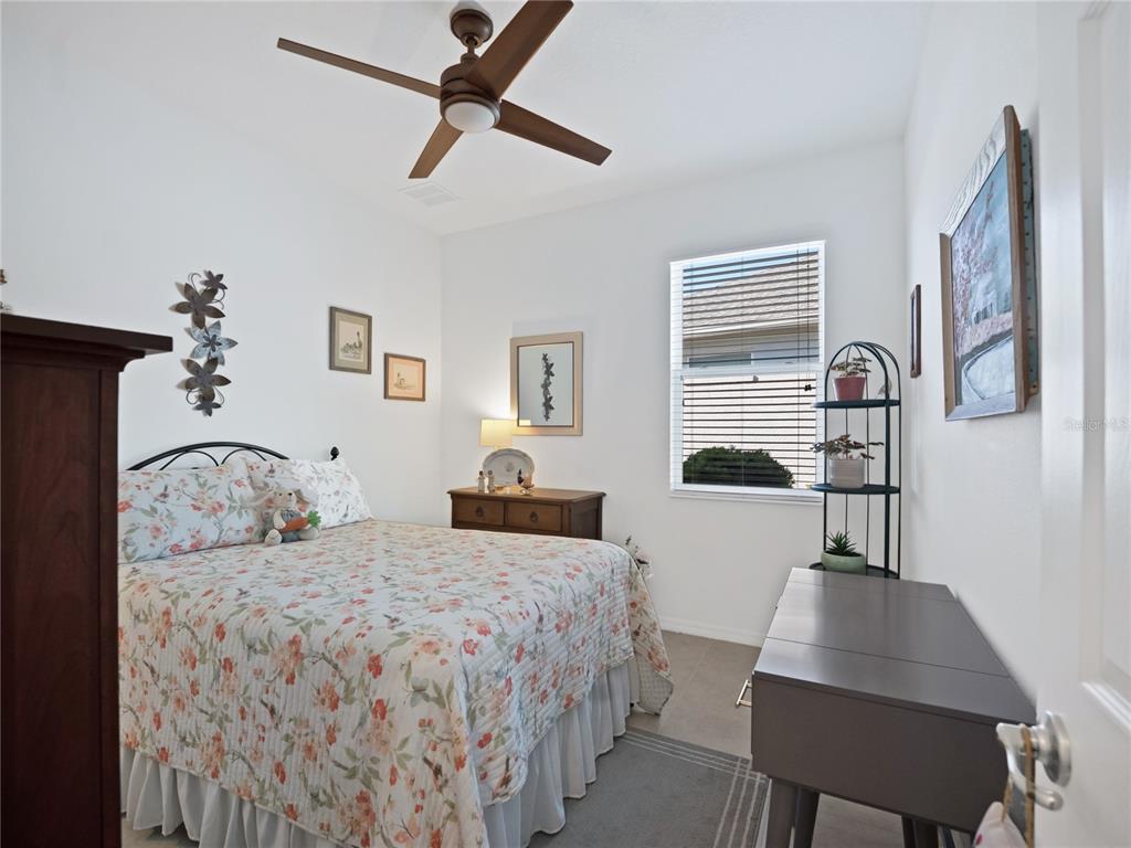 7832 Southwest 86th Loop Ocala, FL 34476 - Photo 9 of 40 a bedroom with a bed and a table with the bookshelf