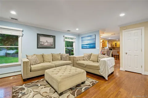 a living room with couches and large window with garden view