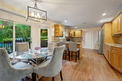 a view of a dining room with furniture a chandelier and wooden floor