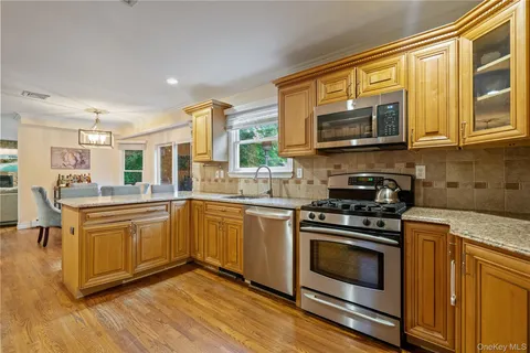 a kitchen with stainless steel appliances granite countertop a stove a sink and a microwave