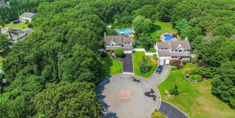 a aerial view of a house with a yard and large trees