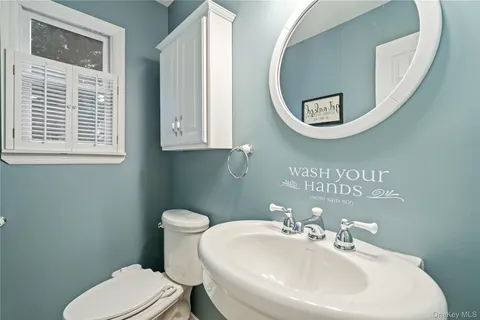 a bathroom with a toilet a sink and mirror