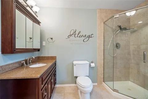 a bathroom with a granite countertop sink toilet and shower