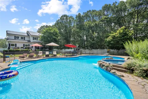a swimming pool with outdoor seating and yard