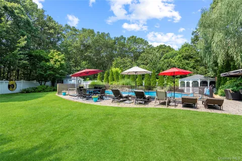 a view of a backyard with swimming pool and furniture