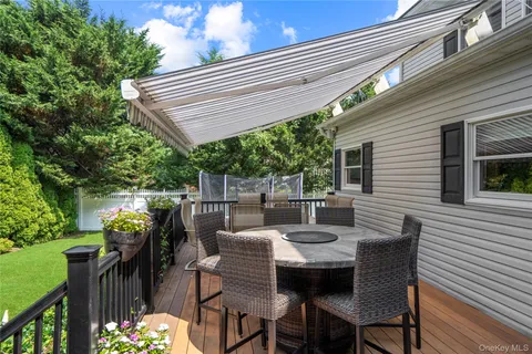 a view of a patio with a table and chairs and a barbeque