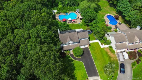 an aerial view of a house with a garden and swimming pool