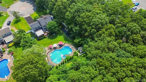 an aerial view of a house with a yard and outdoor seating