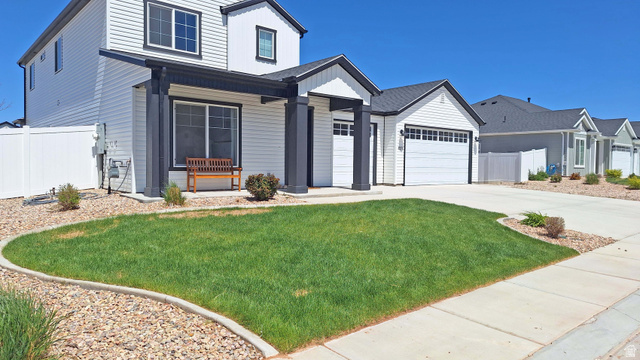 1127 4240 North Enoch, UT 84721 - Photo 5 of 56 View of front facade with driveway, an attached garage, board and batten siding, and a porch