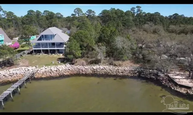 a view of a house with a yard next to a lake