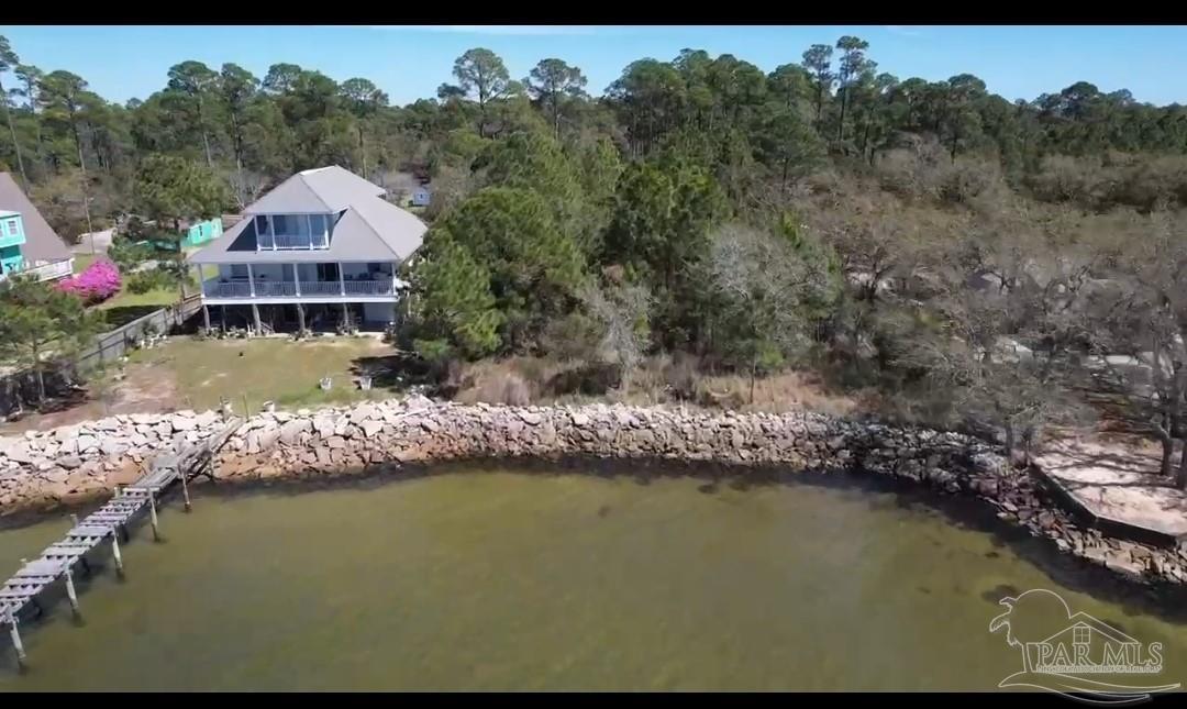 879 Dolphin Road Milton, FL 32583 - Photo 3 of 4 a view of a house with a yard next to a lake