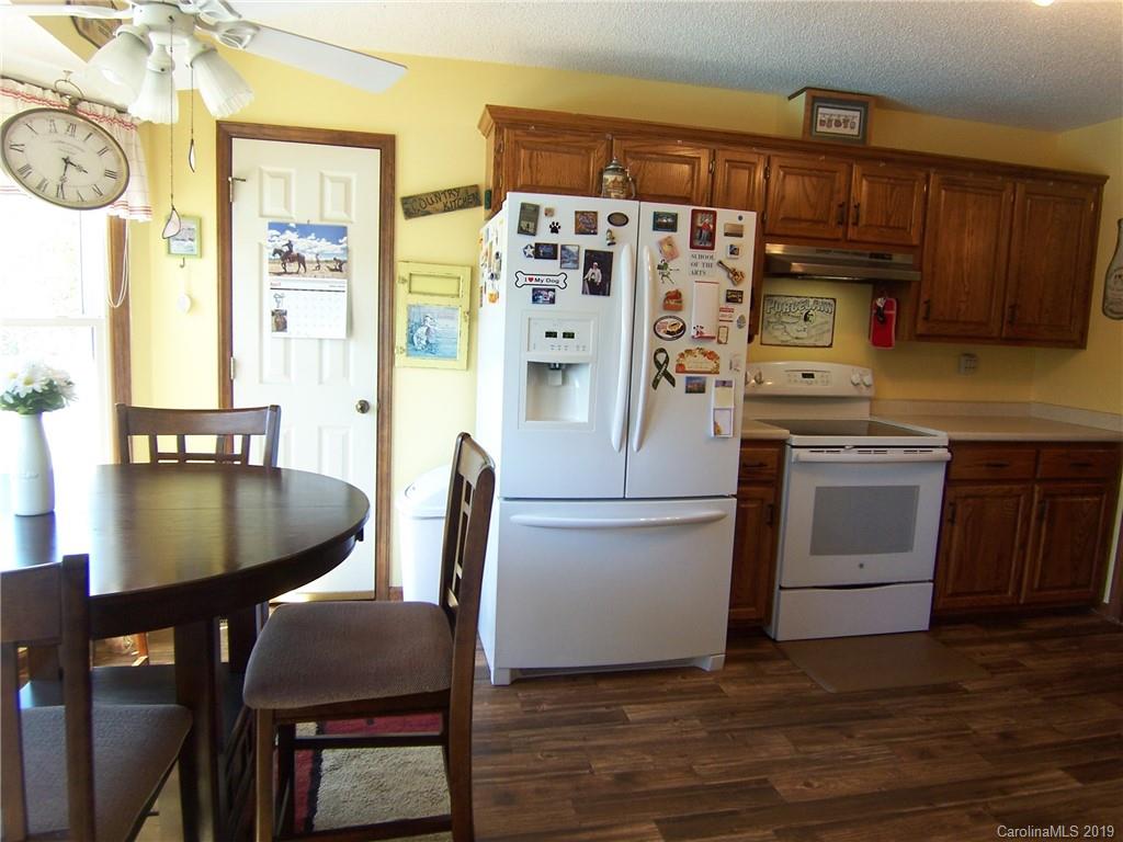 124 Laren Road Shelby, NC 28152 - Photo 14 of 30 a kitchen with stainless steel appliances granite countertop a stove a refrigerator a dining table and chairs with wooden floor