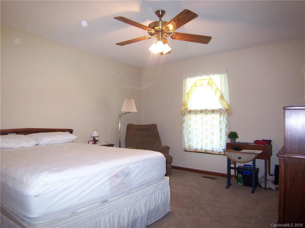 124 Laren Road Shelby, NC 28152 - Photo 20 of 30 a bedroom with a bed and a chandelier