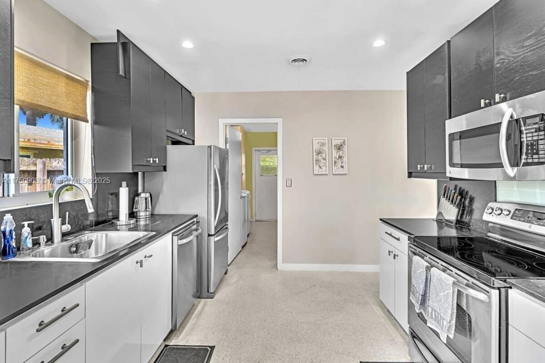 4316 Garfield Street Hollywood, FL 33021 - Photo 12 of 36 a kitchen with stainless steel appliances granite countertop a sink stove and refrigerator