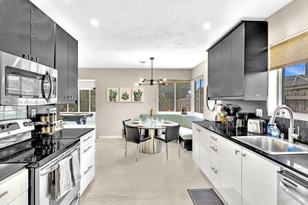 4316 Garfield Street Hollywood, FL 33021 - Photo 14 of 36 a kitchen with stainless steel appliances a sink stove and cabinets