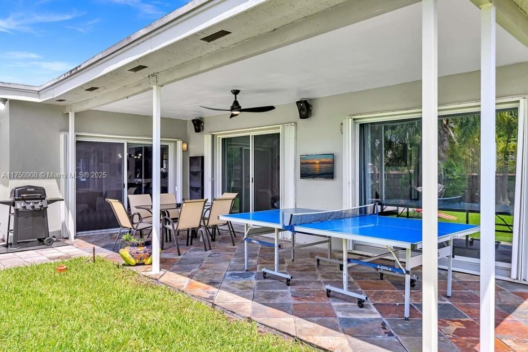 4316 Garfield Street Hollywood, FL 33021 - Photo 18 of 36 a view of a patio with table and chairs potted plants with wooden floor and floor to ceiling window