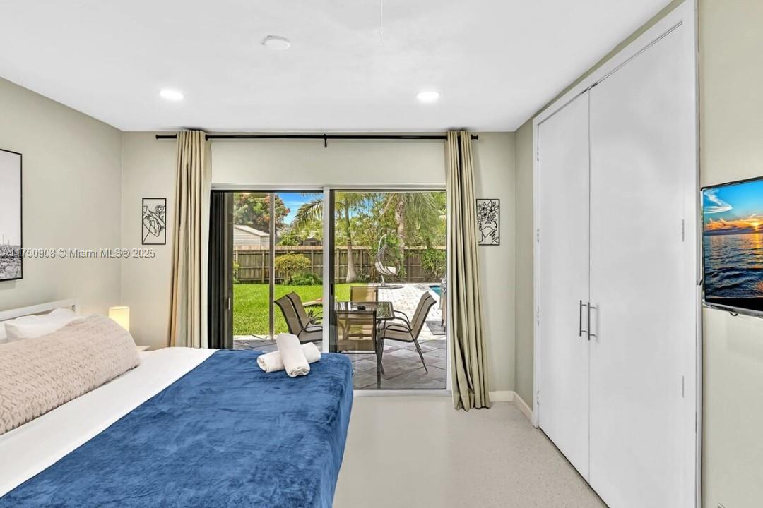 4316 Garfield Street Hollywood, FL 33021 - Photo 10 of 36 a spacious bedroom with a large bed and glass window