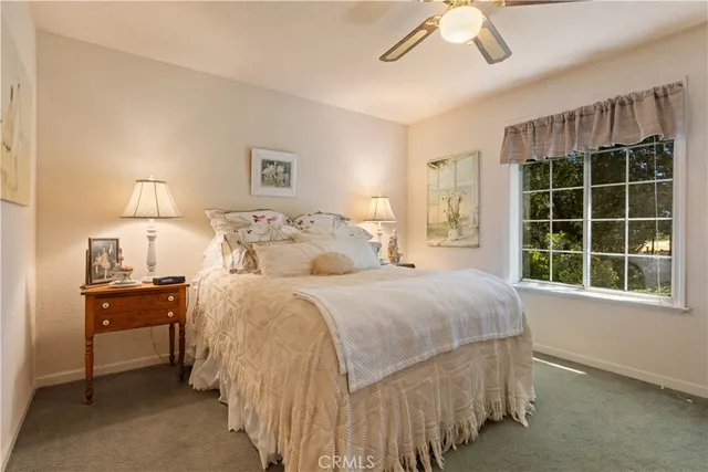 a spacious bedroom with a bed a window and a flat screen television