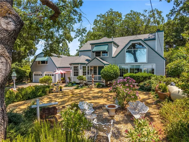 a balcony with table and chairs and potted plants