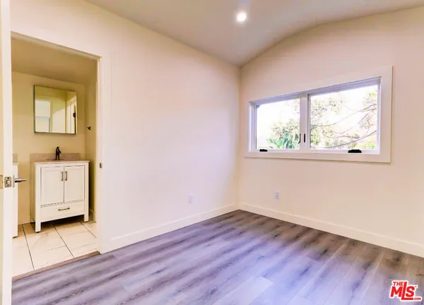 an empty room with wooden floor and a window