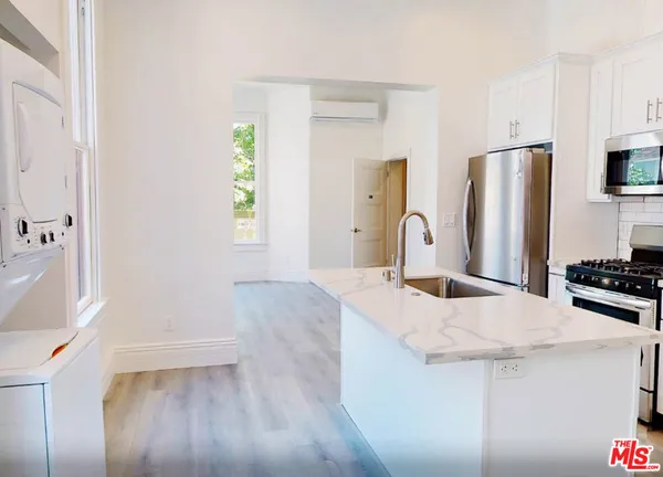 a kitchen with granite countertop a sink stove and refrigerator