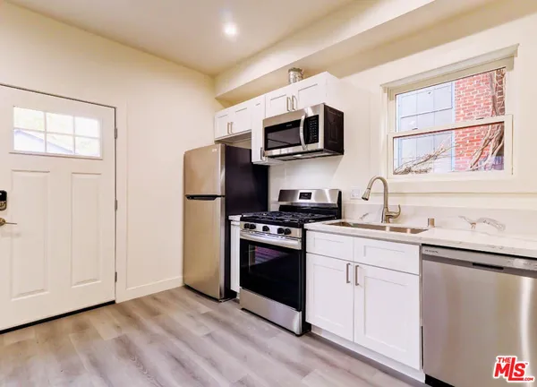 a kitchen with stainless steel appliances granite countertop a stove a sink and a microwave