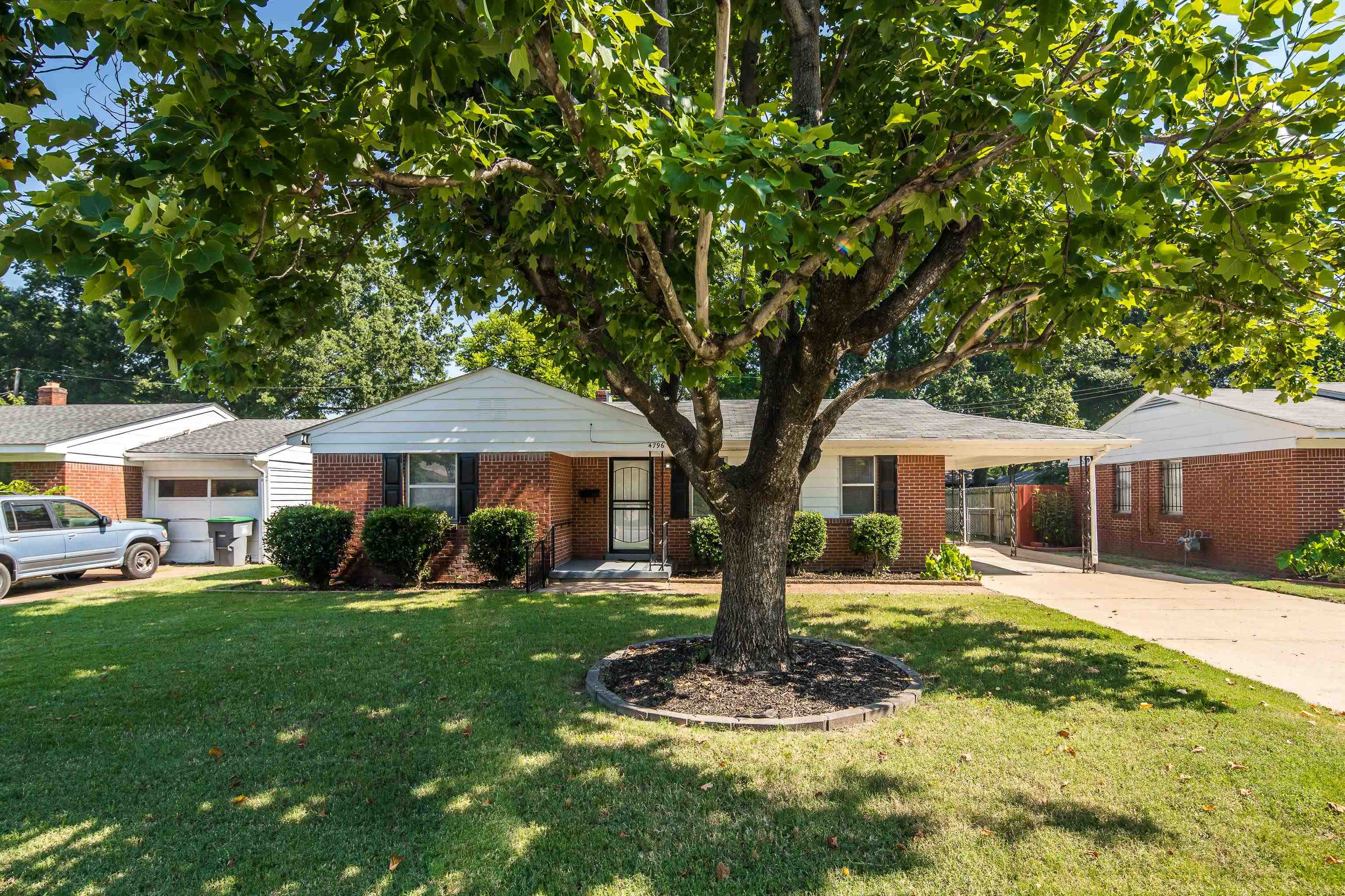4796 Quince Road Memphis, TN 38117 - Photo 2 of 22 a front view of a house with a yard porch and tree