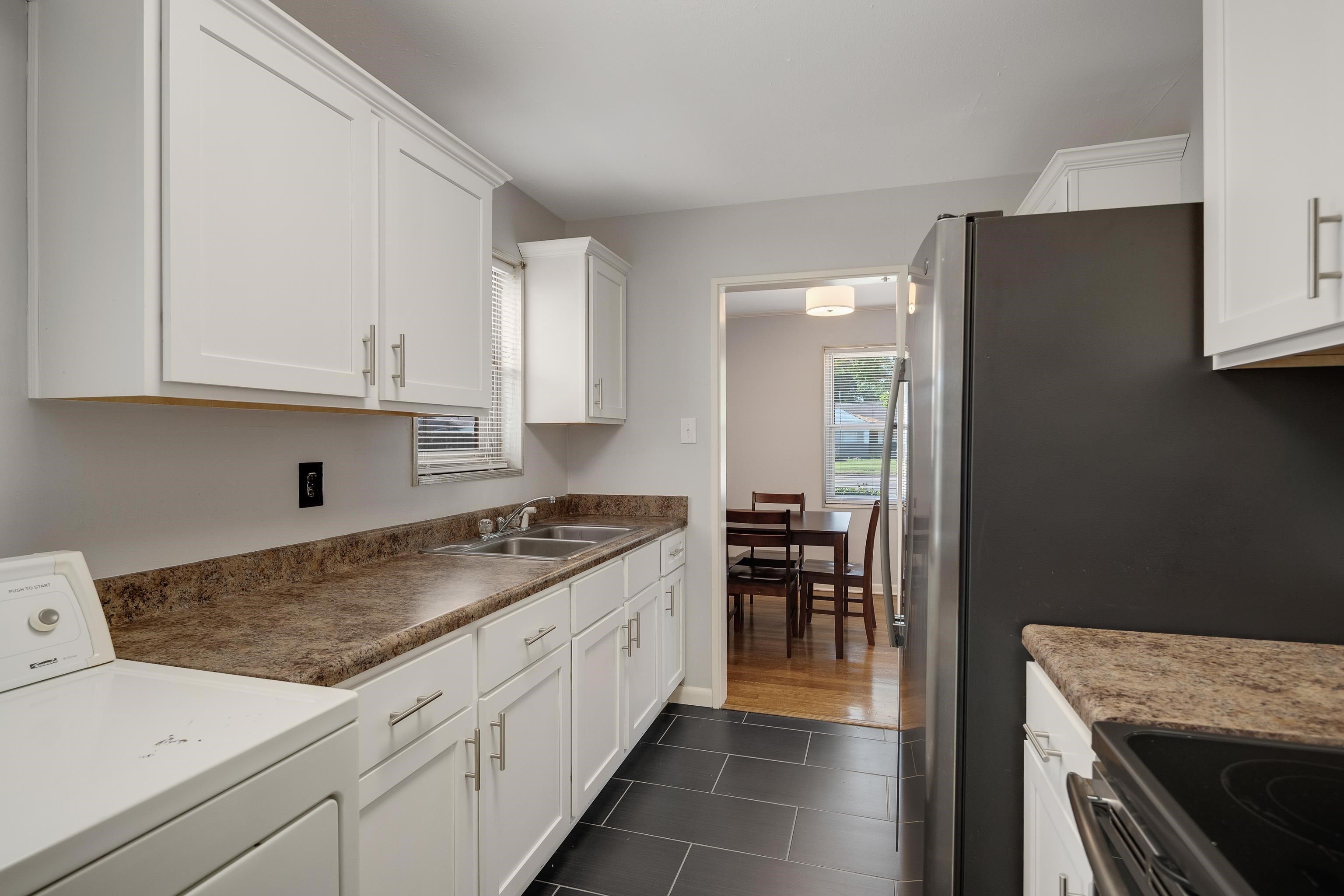 4796 Quince Road Memphis, TN 38117 - Photo 7 of 22 a kitchen with granite countertop a sink stove and cabinets