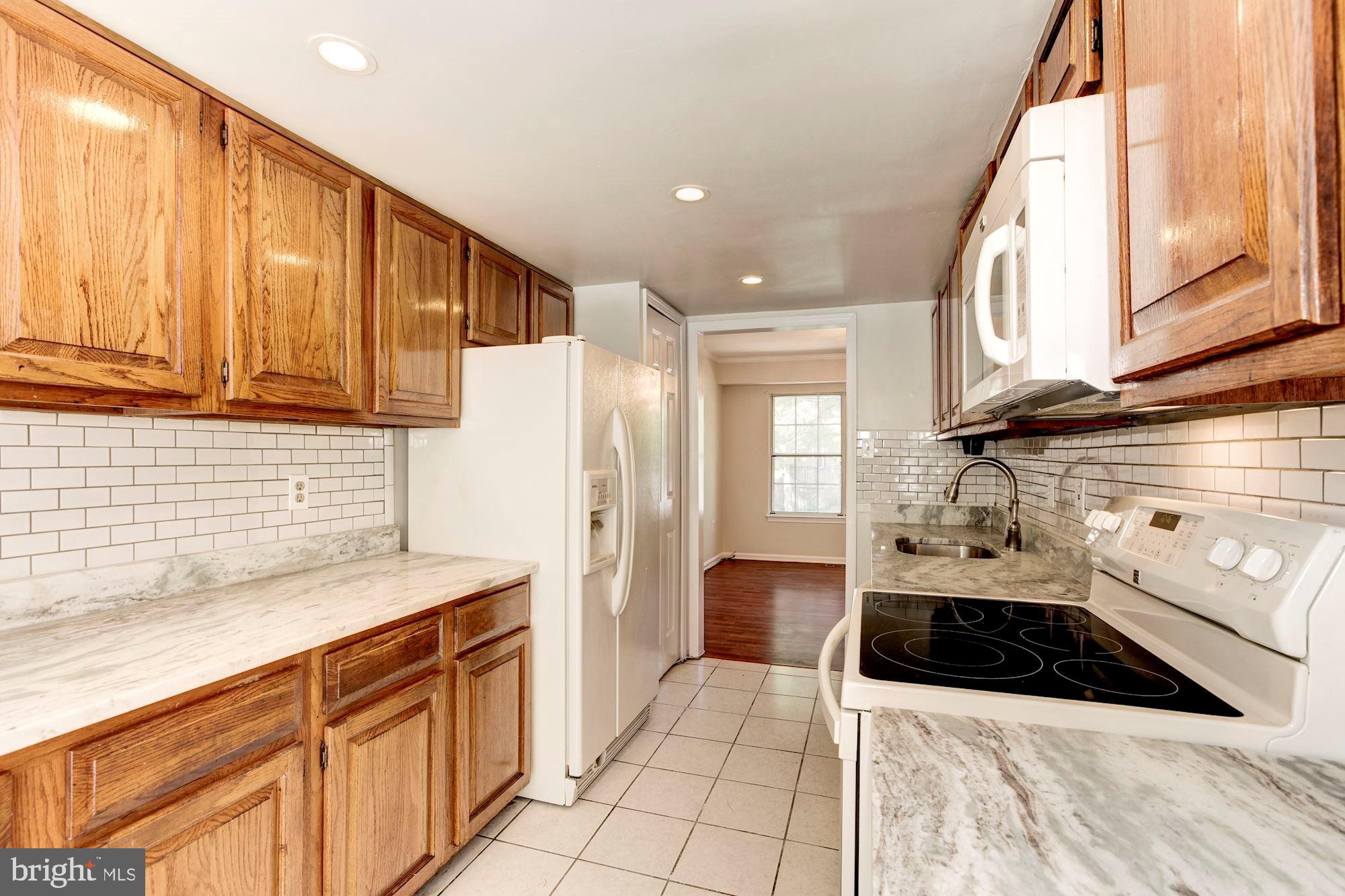 14518 MacBeth Drive Silver Spring, MD 20906 - Photo 11 of 43 a kitchen with stainless steel appliances a sink a stove a refrigerator and cabinets
