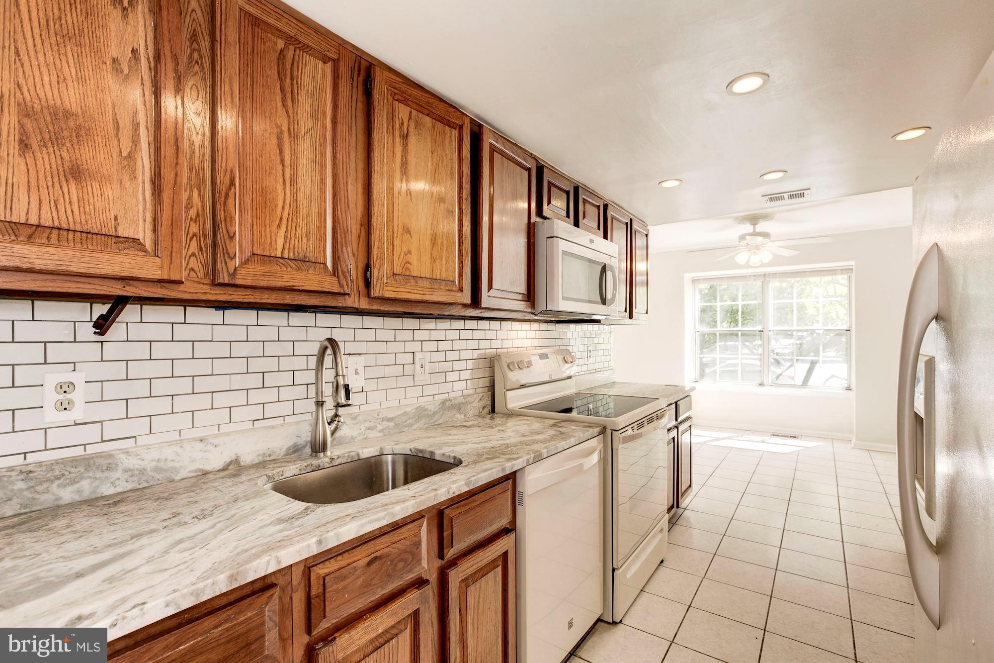 14518 MacBeth Drive Silver Spring, MD 20906 - Photo 14 of 43 a kitchen with stainless steel appliances granite countertop a sink stove and refrigerator