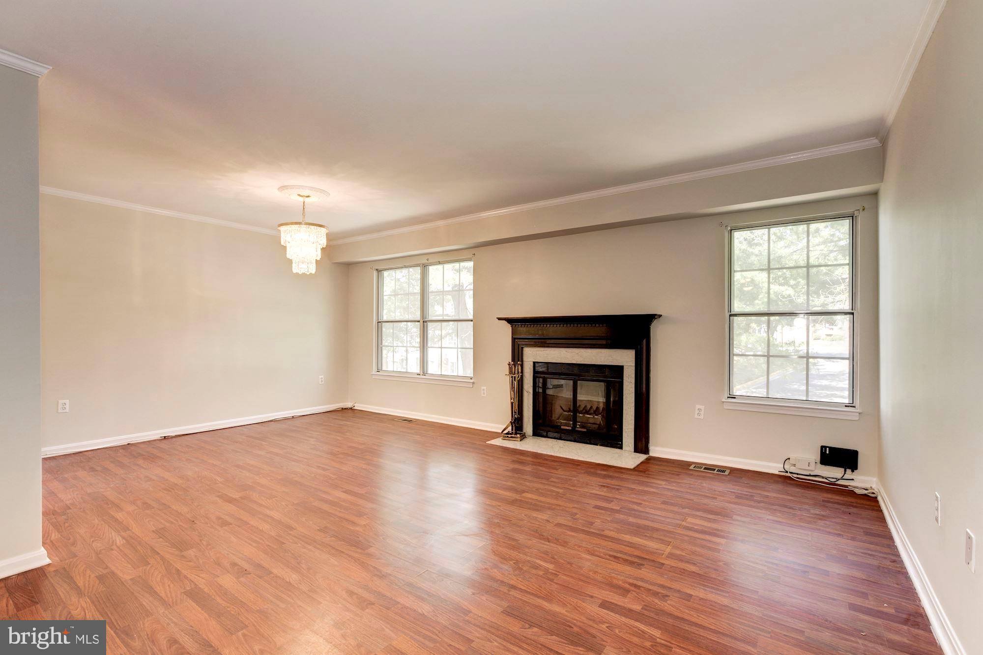 14518 MacBeth Drive Silver Spring, MD 20906 - Photo 19 of 43 an empty room with wooden floor fireplace and windows