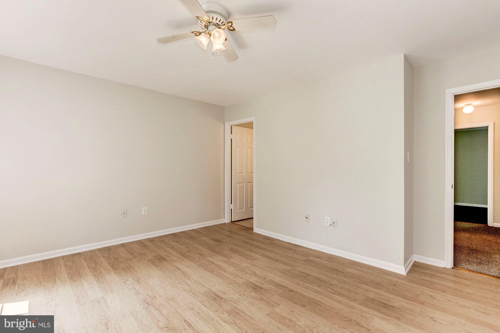 14518 MacBeth Drive Silver Spring, MD 20906 - Photo 24 of 43 an empty room with wooden floor and chandelier fan