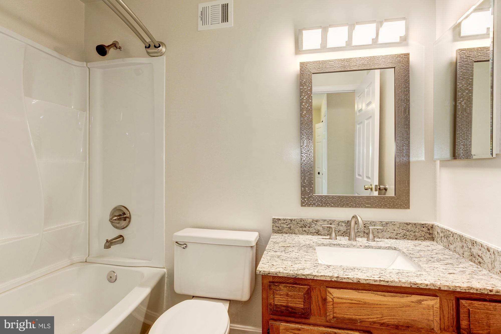 14518 MacBeth Drive Silver Spring, MD 20906 - Photo 31 of 43 a bathroom with a granite countertop sink toilet and shower