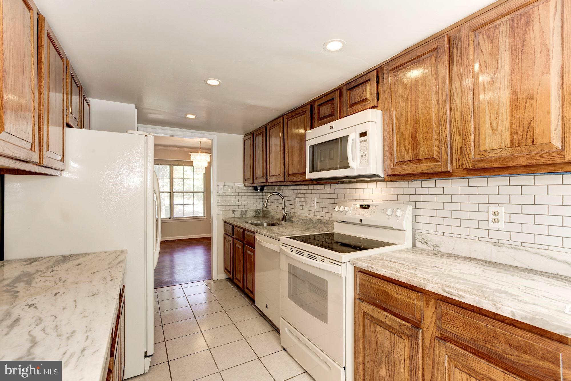 14518 MacBeth Drive Silver Spring, MD 20906 - Photo 10 of 43 a kitchen with stainless steel appliances granite countertop a stove a sink and a microwave